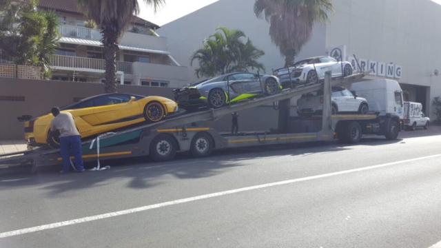 Car Carrier Being Loaded With Sports Cars